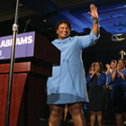 Stacy Abrams waves aside podium.