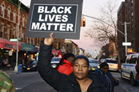 Woman holds Black Lives Matter sign.