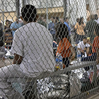 Children behind chain-link fence.