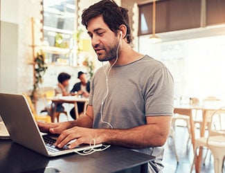 Man with computer at coffeeshop.