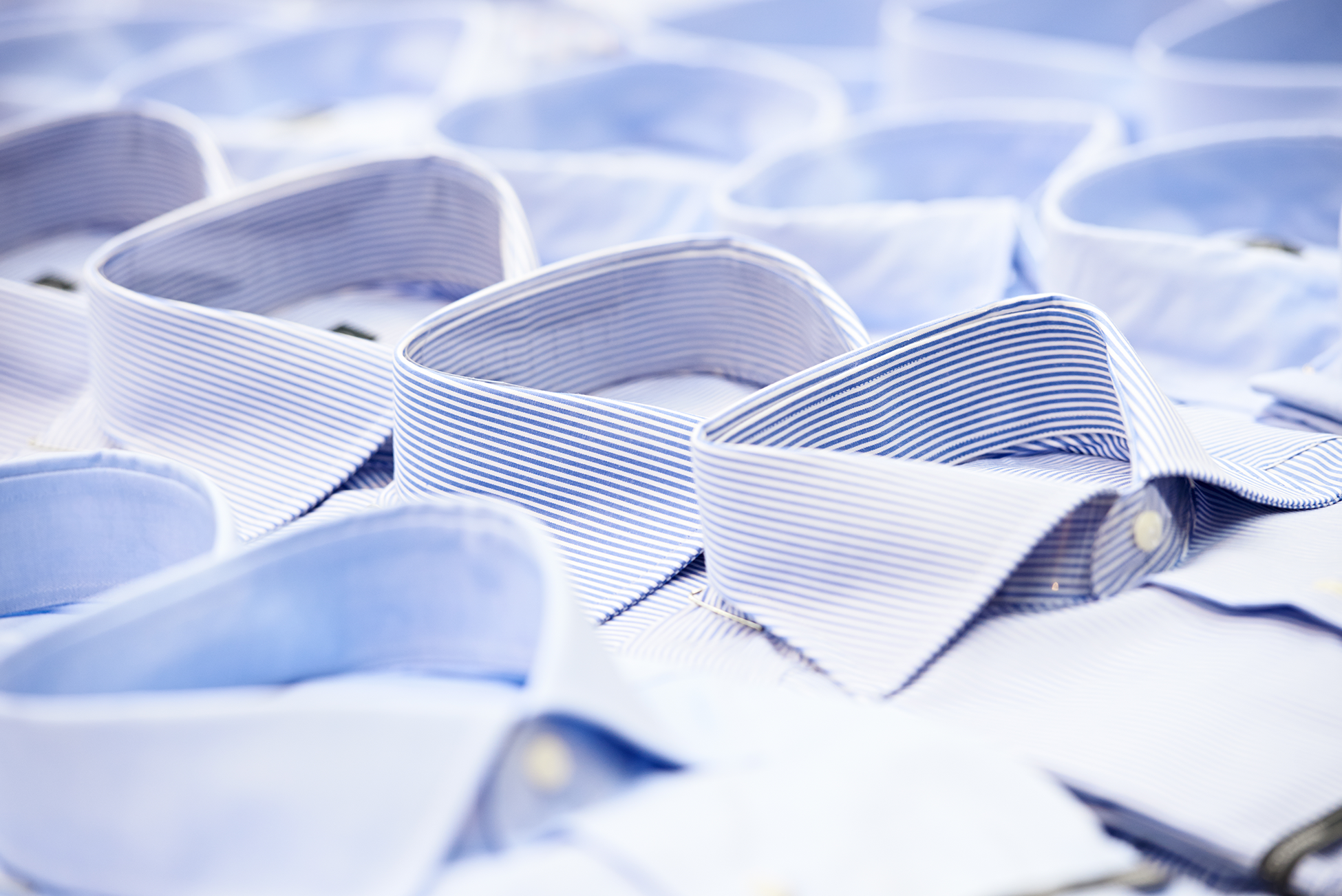 Rows of blue collared shirts stacked as if on a store display