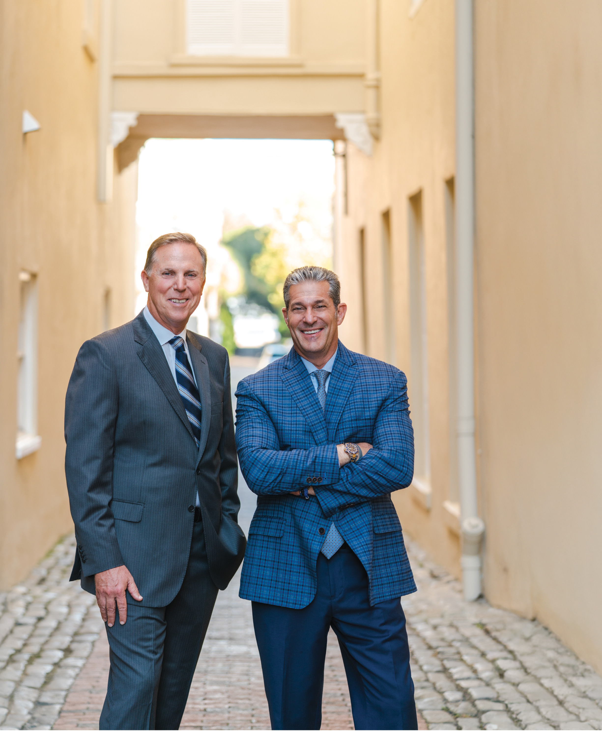 Two smiling lawyers in a courtyard