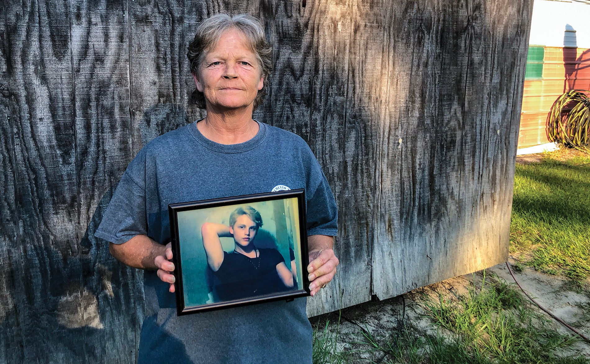 Woman holding a photograph of her son