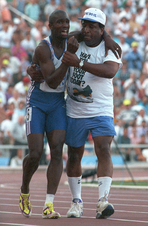 Athlete leaning on an older man