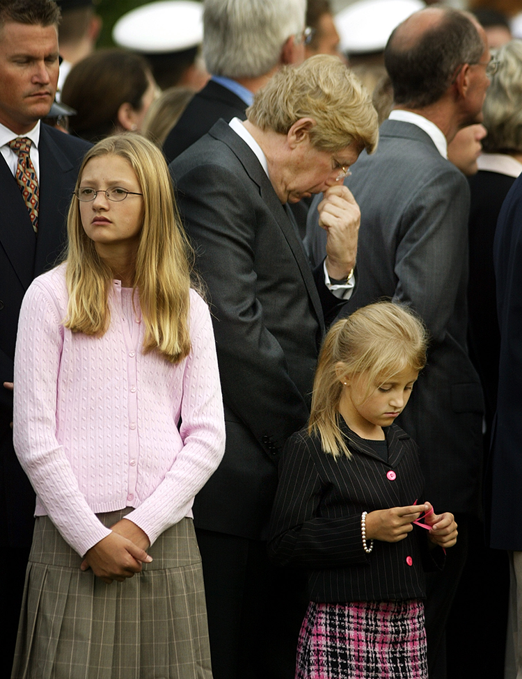 Grieving man and two little girls in a crowd