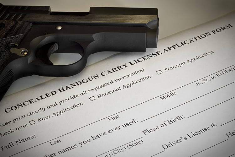 Handgun on top of a black concealed-carry-permit application form