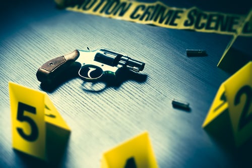 crime scene with tape and gun
