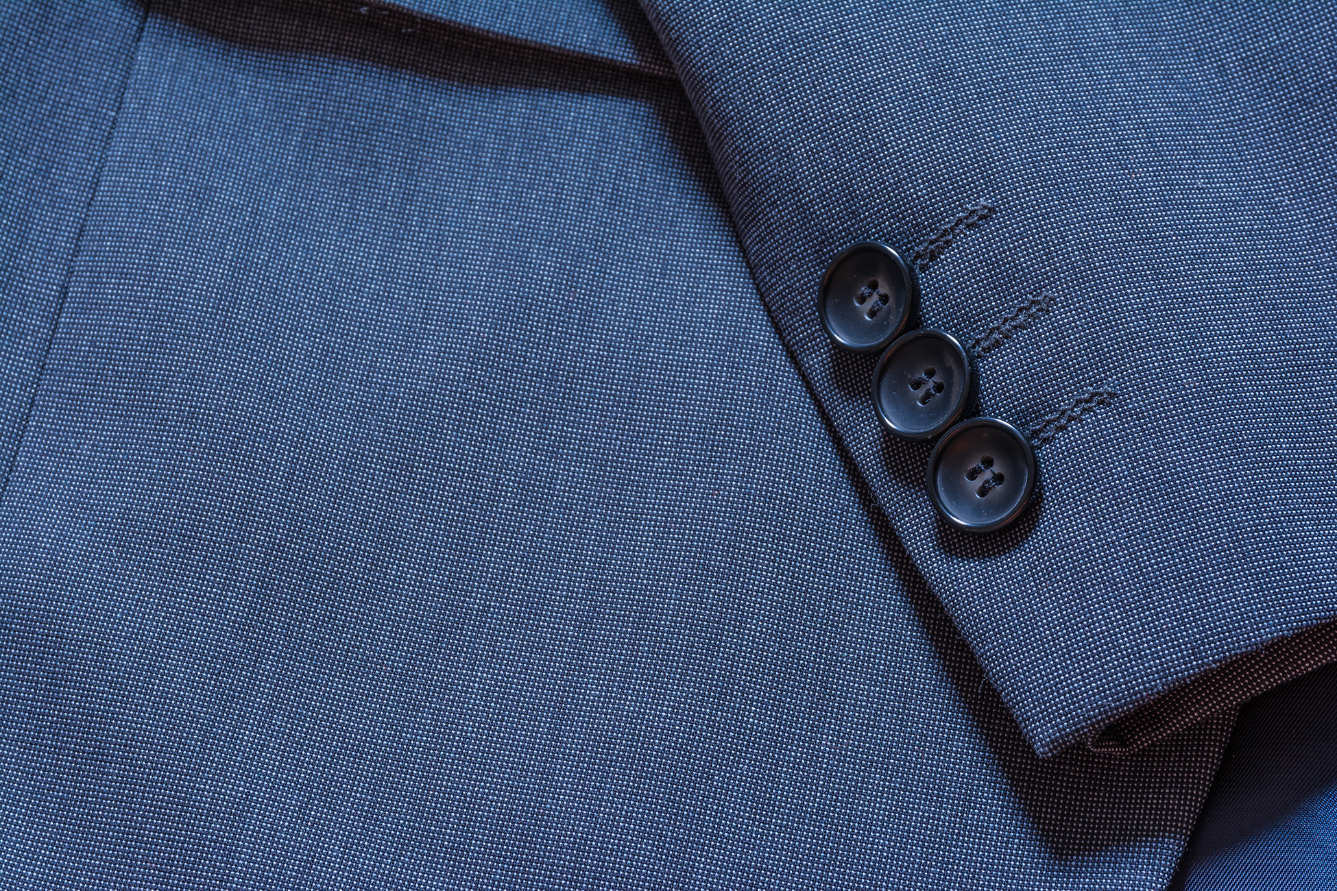 The cuff and buttons of a navy blue suit jacket